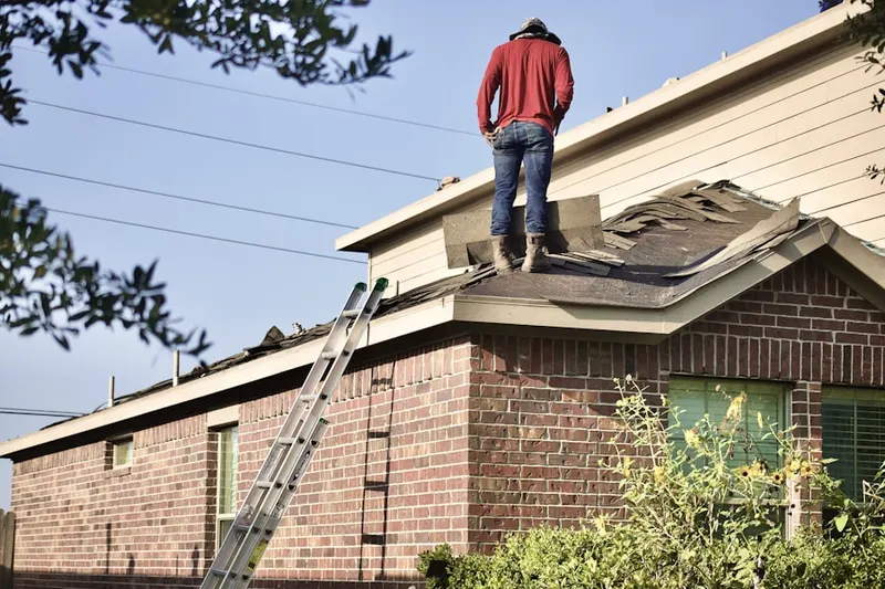 Professional roofer working on a residential roof in Woods Corners